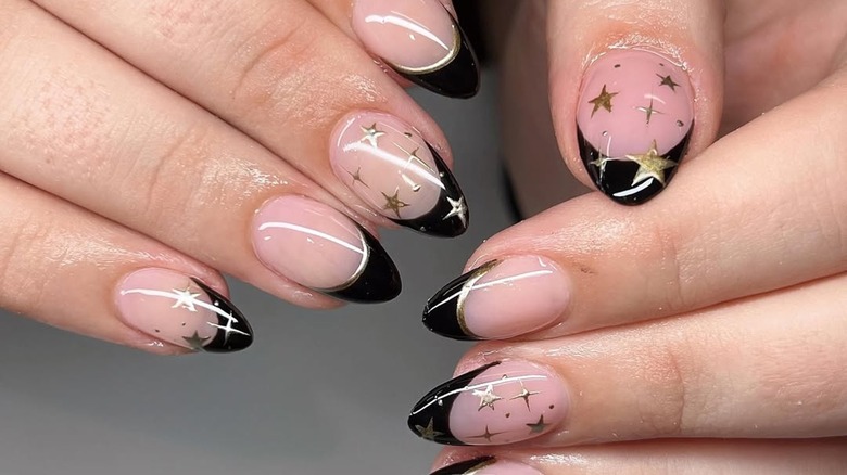 French manicure with black tips and gold stars