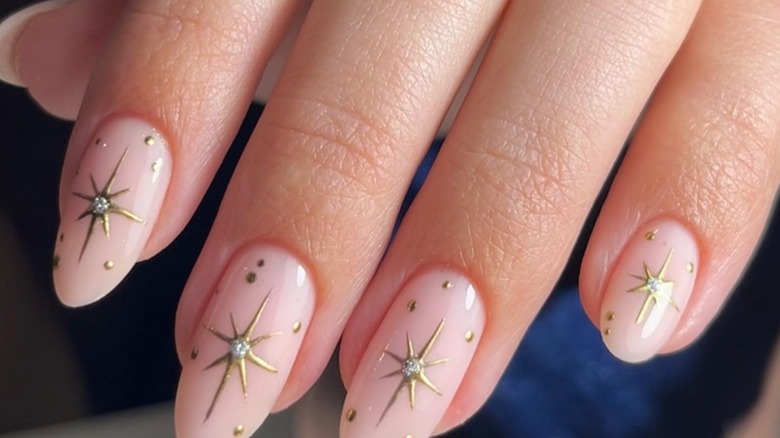 Nails with a nude base and large gold stars