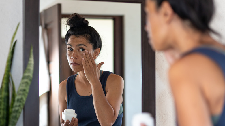 Woman moisturizing her face 