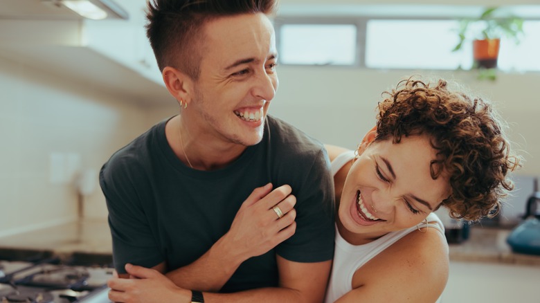 Young queer couple laughing together