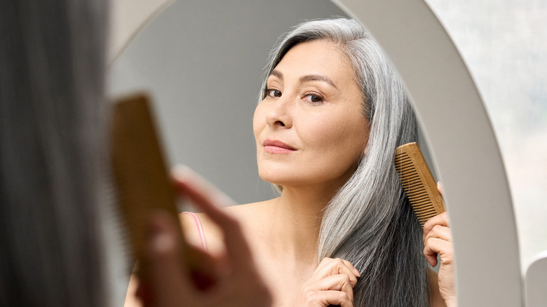 Woman combing gray hair