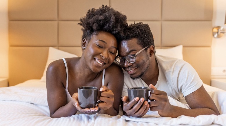 Couple talking in bed with tea