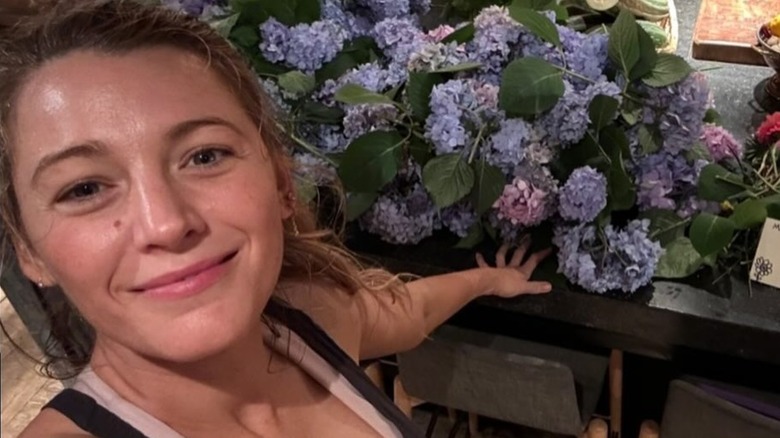 Blake Lively next to flowers, not wearing makeup