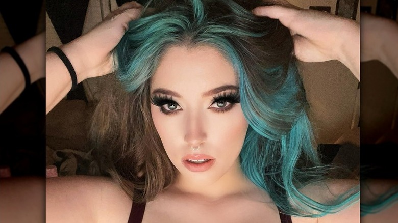 Woman with turquoise hair framing face
