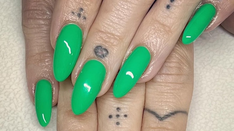 Close-up of nails with a green manicure