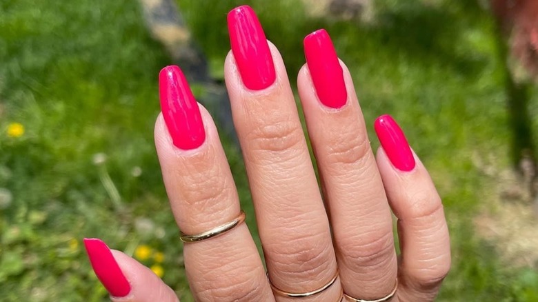 Close-up of raspberry-colored nails