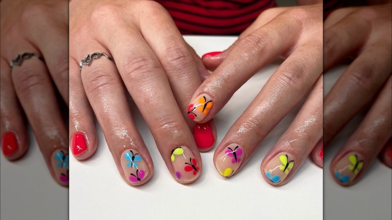 Hands with jelly nails and butterfly designs