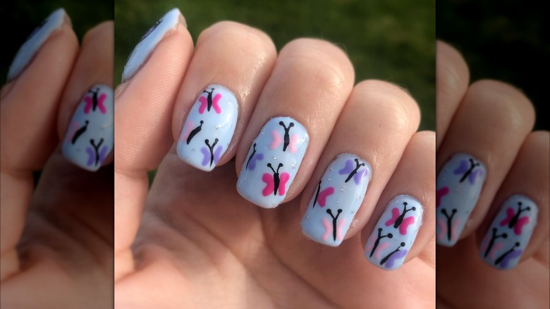 Blue nailed with painted pink and purple butterflies