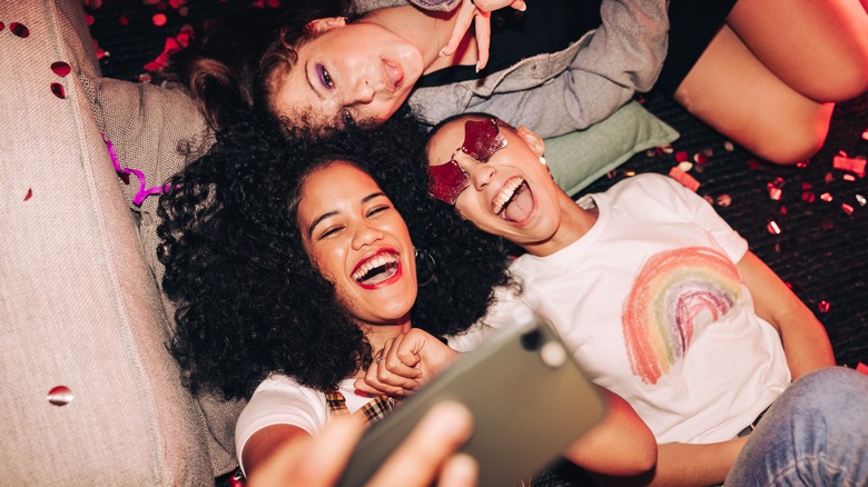Three women smiling taking selfie