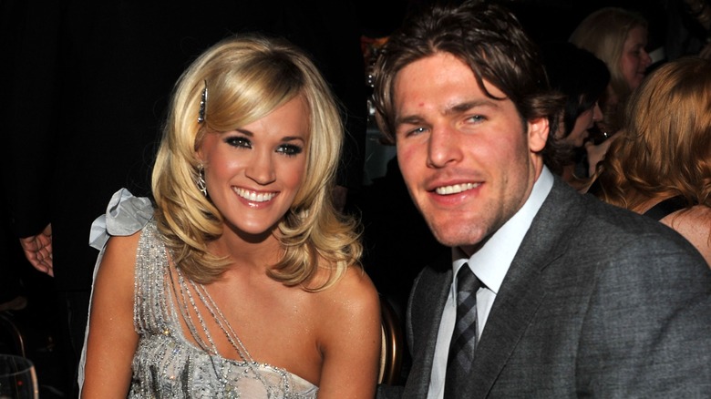 Carrie Underwood sitting next to Mike Fisher