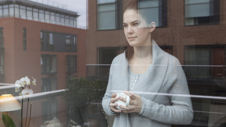 Thoughtful woman contemplates at window