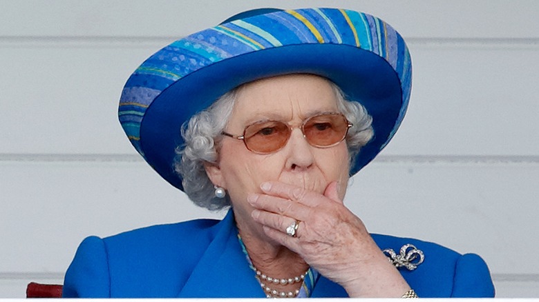Queen Elizabeth with her hand over her mouth