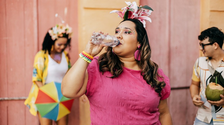 A woman drinking water at a festival