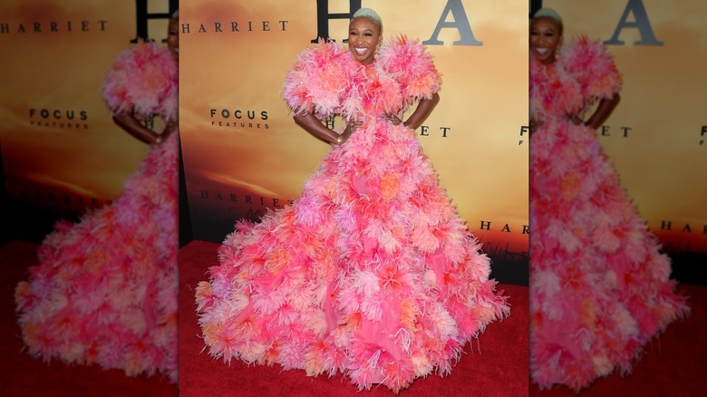 Cynthia Erivo smiling and posing in a textured, pink-and-orange gown in 2019