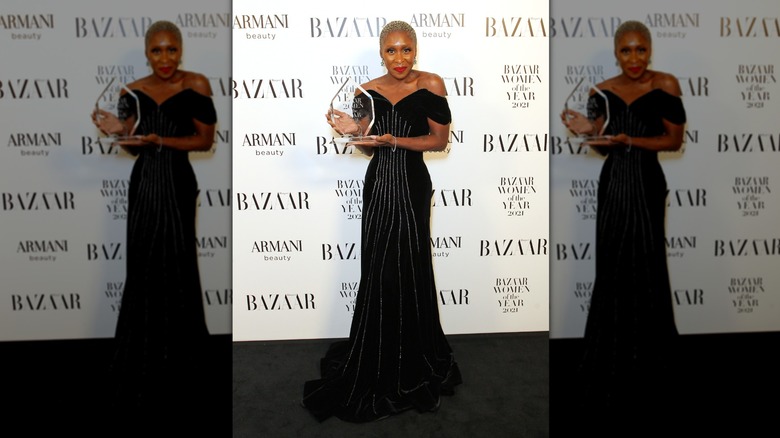 Cynthia Erivo holding a Harper's Bazaar Woman of the Year Award while smiling