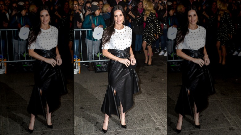 Demi Moore on a sidewalk near a barricade and crowds