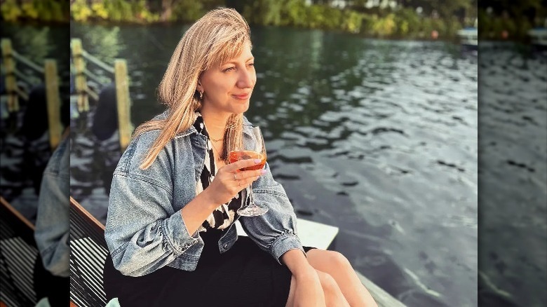 Woman sipping on wine by river