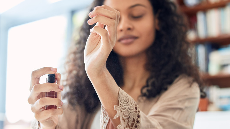 Woman applying perfume