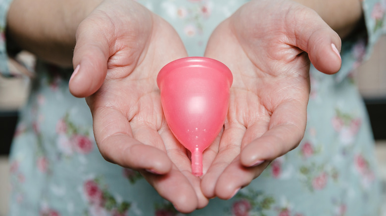 hands holding menstrual cup