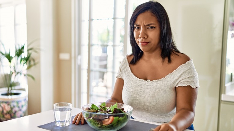 Woman looks unimpressed with salad