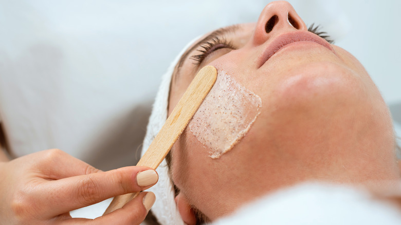 Woman using physical exfoliant 