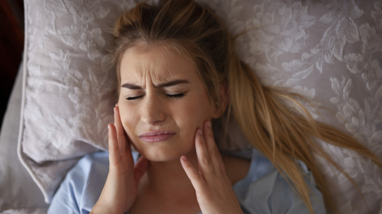 Woman holding jaw in pain