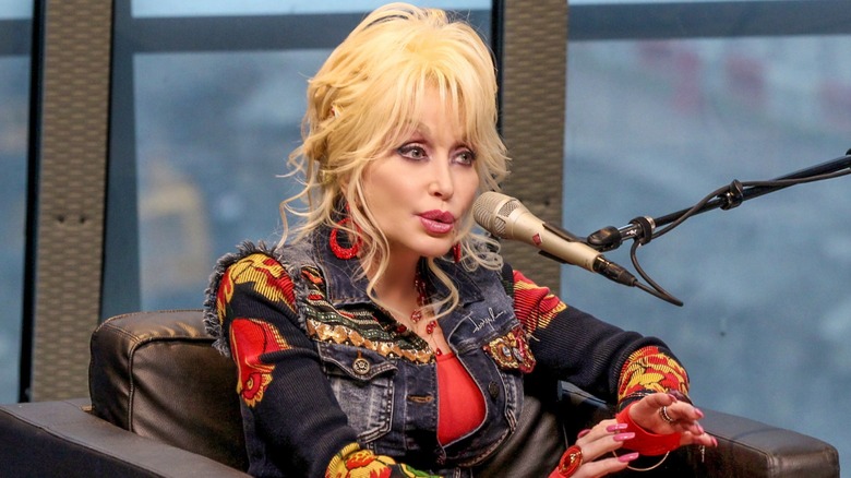 Dolly Partons speaking into a microphone for a podcast