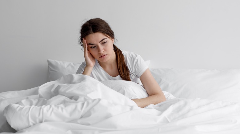 Woman looking overwhelmed in bed
