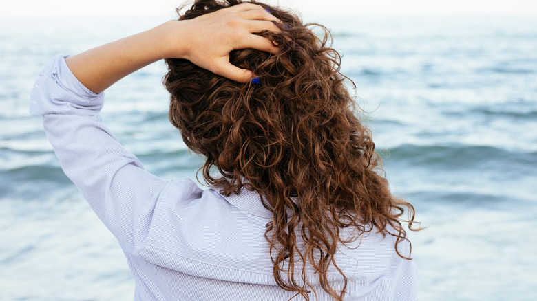 Woman with curls touching hair
