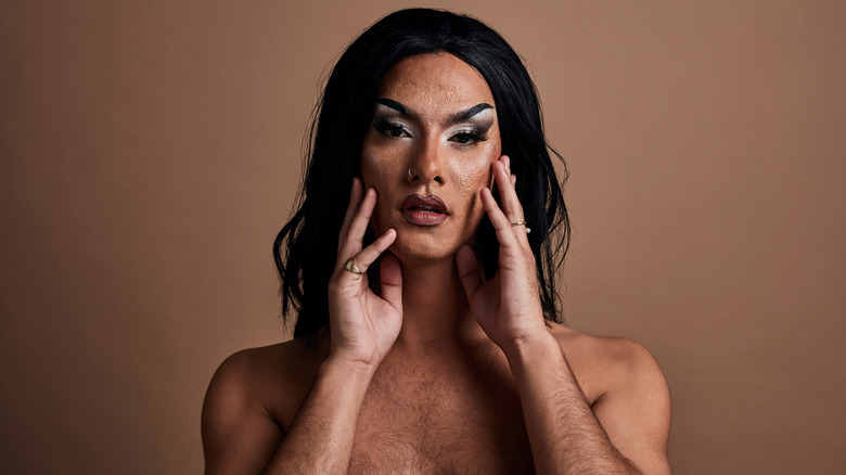 BIPOC drag queen touching face