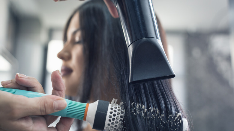 woman brushing hair and drying