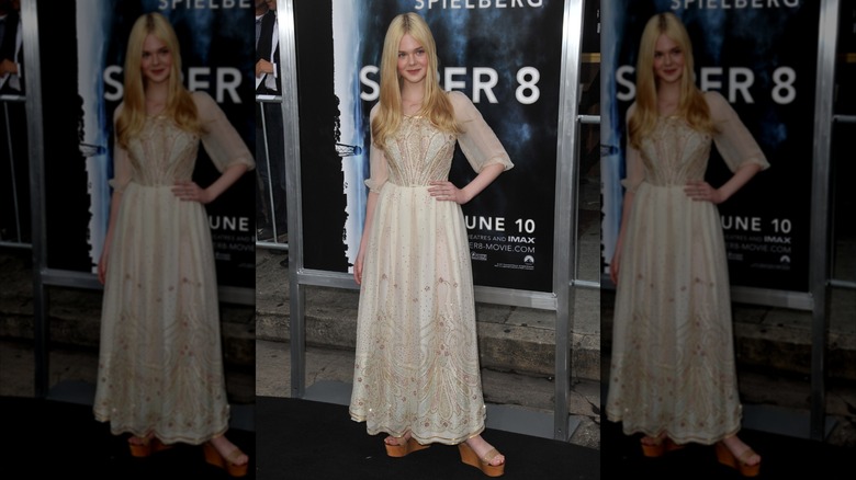 Elle Fanning posing in a cream dress at the premiere of "Super 8" in 2011