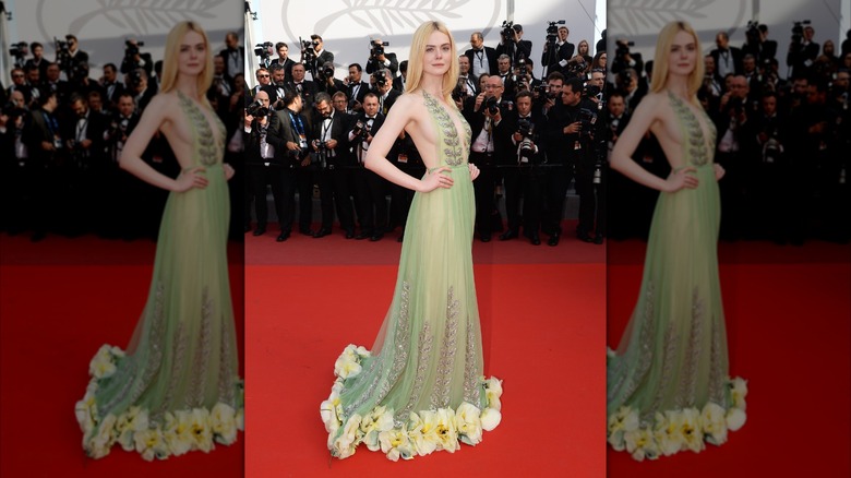 Elle Fanning posing in sheer, green Gucci dress at the 2017 Cannes Film Festival