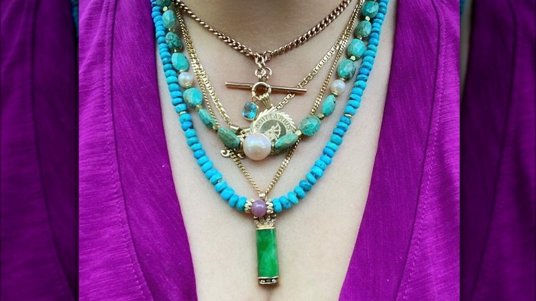 Person wearing stacked statement necklaces