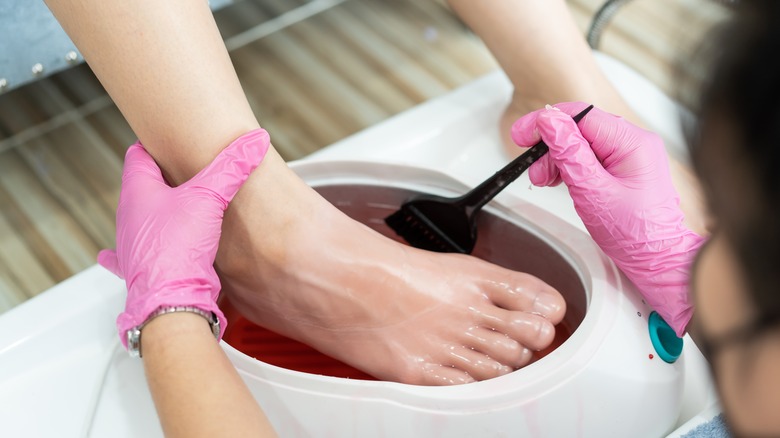 Close up of person getting paraffin wax pedicure