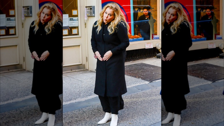 Amy Schumer touching her baby bump