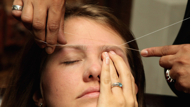 woman getting eyebrow threading