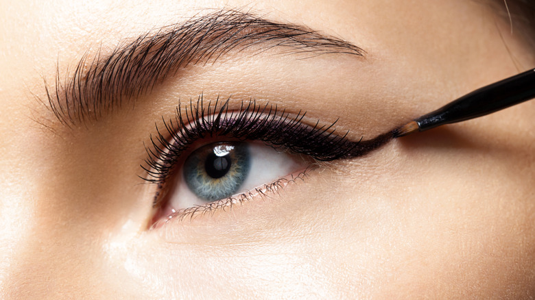 Close-up of woman applying black eyeliner 
