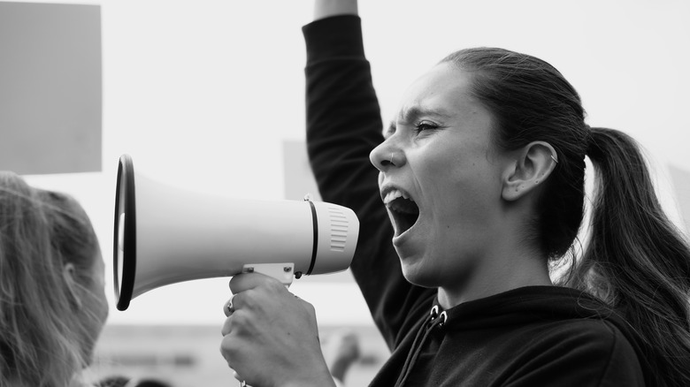 Woman using megaphone and holding her arm in the air