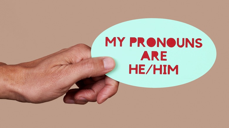 Person with their pronouns written down