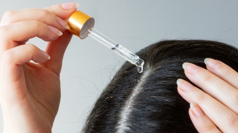 Woman applies glycolic acid on hair