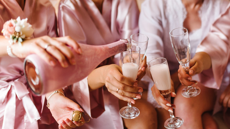 Bridesmaids clinking champagne glasses together