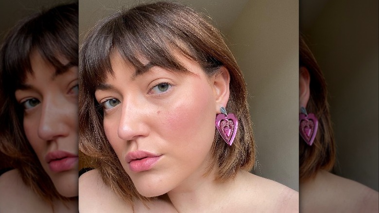 Closeup of person with pink heart earrings