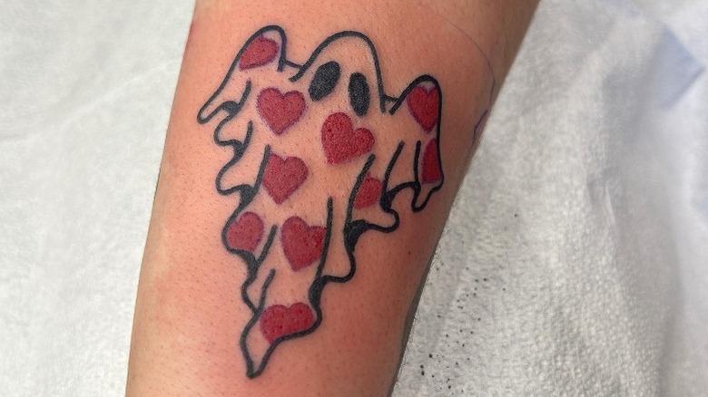Arm with ghost heart tattoo