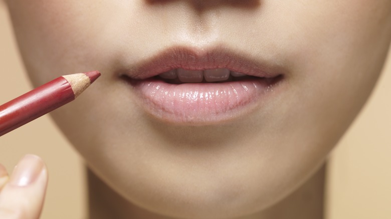 woman using lip pencil 