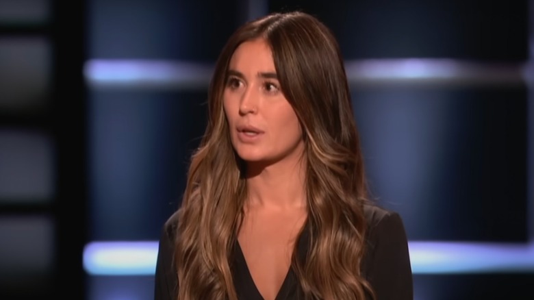 Elly Gheno on Shark Tank in a black shirt looking shocked