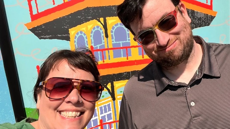 Michael Malkin and Luce Fuller take a selfie in front of a mural