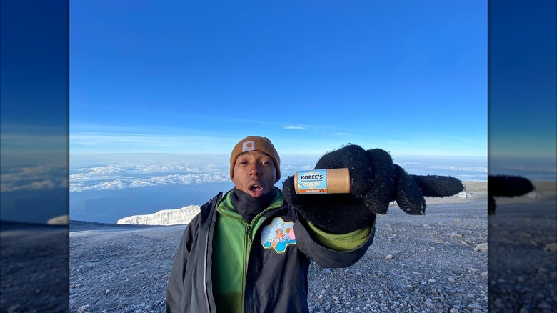 Kobee Harris, founder of Kobee's Lip Balm, posing for a photo with company product