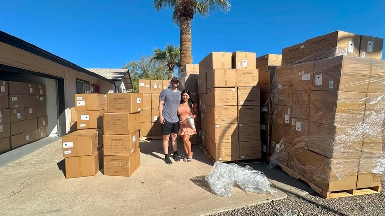 Jacqueline and Jeremy Samuelson surrounded by hundreds of boxes of their nursing covers