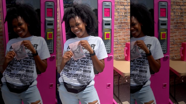 Founder, Ashlee Lena Turner, poses in front of a vending machine that provides The Pocket Panty in Chicago